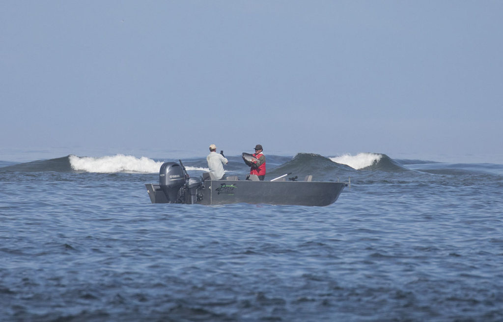A fisherman holds up his Chinook salmon catch.